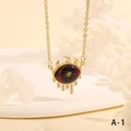 Detailed close-up of golden evil eye pendant necklace with crystals and tassel fringe - Starry Red Black Tassel Style (NE2265-A-1)