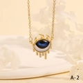 Macro shot of gold Evil Eye necklace featuring blue eye pendant with crystal teardrop tassels - Dark Blue Eye Eyelash Tassel Style (NE2265-A-2)