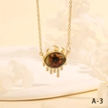 Macro shot of evil eye necklace pendant with orange pupil and white rhinestone details - Orange Realistic Eyeball Tassel Style (NE2265-A-3)