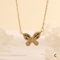 Detalle de un colgante de mariposa dorada con gemas de colores y pétalos blancos - Estilo Gema de Cuatro Colores (NE2274-C)
