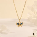 Detailed macro view of gold butterfly pendant with sparkling blue marquise stones - Sky Blue Zirconia (NE2275-E)