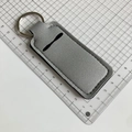 Close-up of neoprene leopard print lipstick holder keychain with a sturdy metal ring - Tech Gray