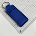 Blue neoprene lipstick holder keychain with metal ring shown next to a scale for sizing - Royal Blue