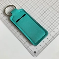 Détail du porte-rouge à lèvres en néoprène vert menthe avec anneau et coutures blanches - Bleu Paon