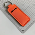 Detail of orange neoprene keychain lipstick holder with black stitching and metal ring - Orange