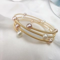 Detailed close-up of handmade 14K gold plated wire wrapped bracelet with freshwater pearls - Gold Multi Loop Spiral Wrapped Pearl Bracelet