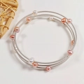 Close-up of triple-layered silver wire bracelet with white and pink freshwater pearls - Silver Three Layer Metal Coil Style / Silver