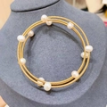 Detailed macro view of 14K gold plated wire-wrapped bracelet with fresh water pearls - Gold Multi Layer Pearl Wrapped Choker