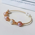 Macro shot of gold wire-wrapped freshwater pearls bracelet with pink and white pearls - Gold Pink Purple White Multi Pearl Woven Style