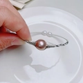 Detail of handmade wire-wrapped bracelet featuring large purple pearl and small white accents - Silver Purple Metallic Luster Large Pearl Style