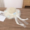 Beige straw sun hat featuring elegant white lace brim and light blue floral accents - Two Blue Flowers Beige