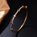 Elegante pulsera de acero inoxidable dorado con circonitas sobre fondo de seda negra - Brazalete de Tuerca Industrial / Dorado