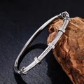 Primer plano de una pulsera de acero inoxidable plateada con detalles de tuercas hexagonales - Brazalete de Tuerca Industrial / Plateado