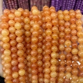 Close-up of polished orange chalcedony round beads with glossy finish for jewelry - A479 Chalcedony - Bright Orange Red
