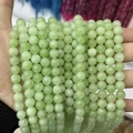 Detail of light green chalcedony round beads with a smooth semi-translucent oily luster - A482 Chalcedony - New Mountain Jade