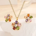 Detailed close-up of gold floral jewelry set with multi-color rhinestones on white stone - Colorful Flower (Necklace + Earrings) Set