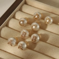 Close-up of vintage pearl stud earrings with crystal-encrusted A, B, C, D letters - English Alphabet Style