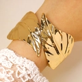 Close-up of golden leaf-shaped open cuff bracelet with polished mirror finish on model - Mirror Double-Leaf Shaped Bangle (11402) / Gold