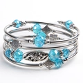 Detail of blue crystal beads and silver floral charms on a layered wrap bracelet - Lake Blue Crystal