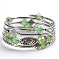 Detail of bohemian layered wrap bracelet with emerald green crystals and floral charms - Light Green Crystal