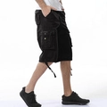 Detail of black cargo shorts featuring side pockets, metal buttons and adjustable drawstring hem - Black