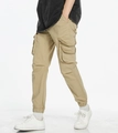 Detail of khaki cargo joggers showing the side flap pocket and elastic cuffs with sneakers - EU 29 / Khaki