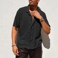 Close-up of black breathable mesh knit polo shirt showing textured hollow-out fabric detail - Black