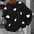 Dettaglio del maglione nero oversize in maglia con motivi a cuore bianchi e polsini a coste - S / Nero