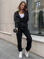 Dettaglio della tuta sportiva nera con felpa con cappuccio e zip e pantaloni coordinati - Taglia S / Top e Pantaloni / Nero
