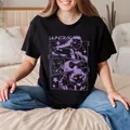 Black cotton Demon Hunter anime T-shirt with purple huntress print worn by model on bed - S / Black