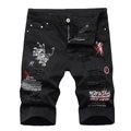 Detail of ripped black denim shorts with red graffiti print and clock badge patch - Black
