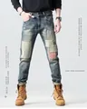 Detail van vintage blauwe slim fit jeans met creatief patchwork en gestreepte stofinzetten - EU 28 / Blauw