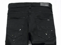 Nahaufnahme der schwarzen Jeans mit Farbspritzern und Lederetikett am Bund für Herren - EU 30 / Schwarz