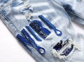 Detail von hellblauen Distressed-Jeans mit blauen Pailletten-Patches und Strass-Akzenten - EU 31 / Blau