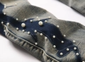 Dettaglio di jeans svasati blu con design patchwork e ricami di perline bianche raffinate - EU 29 / Blu