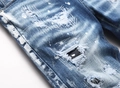 Primo piano dettagliato dei jeans blu con schizzi di vernice bianca e bordi strappati - Stile Originale (AM) / Blu