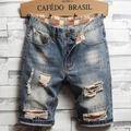 Close-up of ripped denim shorts featuring red plaid fabric lining and distressed details - EU 28 / Medium Blue Washed Heavy Ripped Patchwork (789)