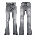 Detail view of grey washed flare jeans featuring distressed holes and white paint splatters - 63627 / EU 28