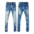 Close-up of distressed blue denim fabric with white paint splatter and faded wash details - EU 28 / Blue Distressed Paint Splatter Ripped Style