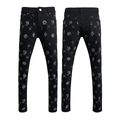 Close-up of black slim fit jeans featuring detailed white graffiti prints and star patterns - EU 28 / Black All-over Graffiti Style