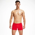 Close-up of red low-rise men's trunk shorts with fine yellow waist trim and polished texture - M / Red