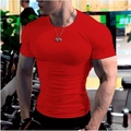 Gros plan d'un t-shirt de sport rouge moulant à col rond sur un modèle en salle - M / Rouge