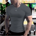 Gros plan d'un t-shirt homme gris foncé moulant soulignant les muscles dans une salle de sport - M / Gris clair