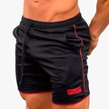 Détail du tissu en maille respirante et logo FLY rouge sur le short de sport noir pour homme - Noir/Rose vif