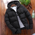 Flat lay of black hooded puffer jacket with quilted texture on dark wood background - Black