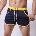 Detail of dark blue mesh sports shorts featuring vibrant yellow piping and white drawstring - M / Navy Blue