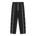 Détail d'un pantalon de sport noir avec bandes latérales blanches et boutons-pression - S / Bas / Noir