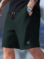 Detail showing waffle-knit texture and drawstrings on men's dark green casual shorts - S / Dark Green