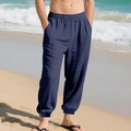 Close-up of men's navy linen beach pants with drawstring waist and elastic cuffs on sand - Navy Blue