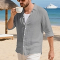 Close-up of grey linen beach shirt with vertical texture and white buttons on a beach - Gray
